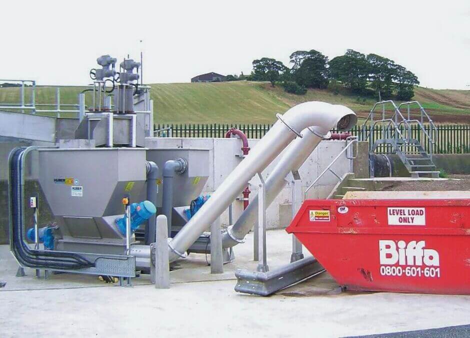 Entwässertes und behandeltes Rechengut wird nach der Behandlung in einen Container abgeworfen