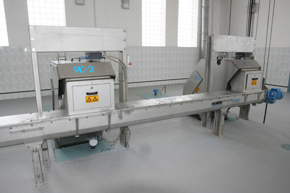 Two screens installed in parallel discharging into one screw conveyor Two screens installed in parallel discharging into one screw conveyor