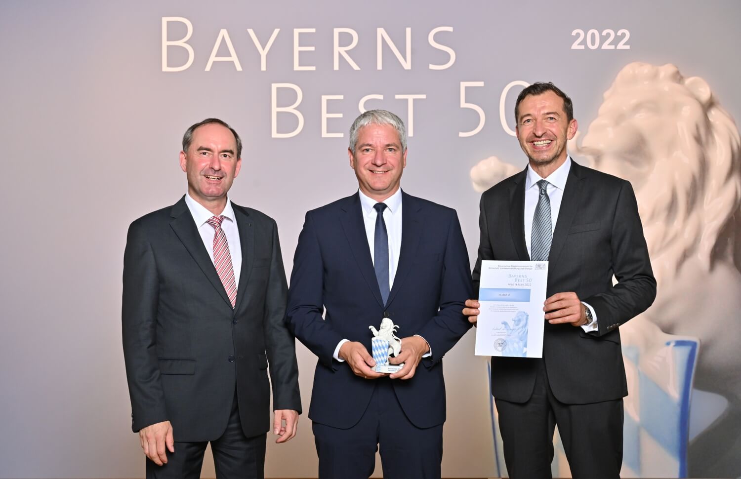Minister of State Hubert Aiwanger (left) handed over the official certificate to Georg Huber (middle), CEO of HUBER SE (© Studio SX HEUSER). 22-08-huber-bayerns-best-50-teaser