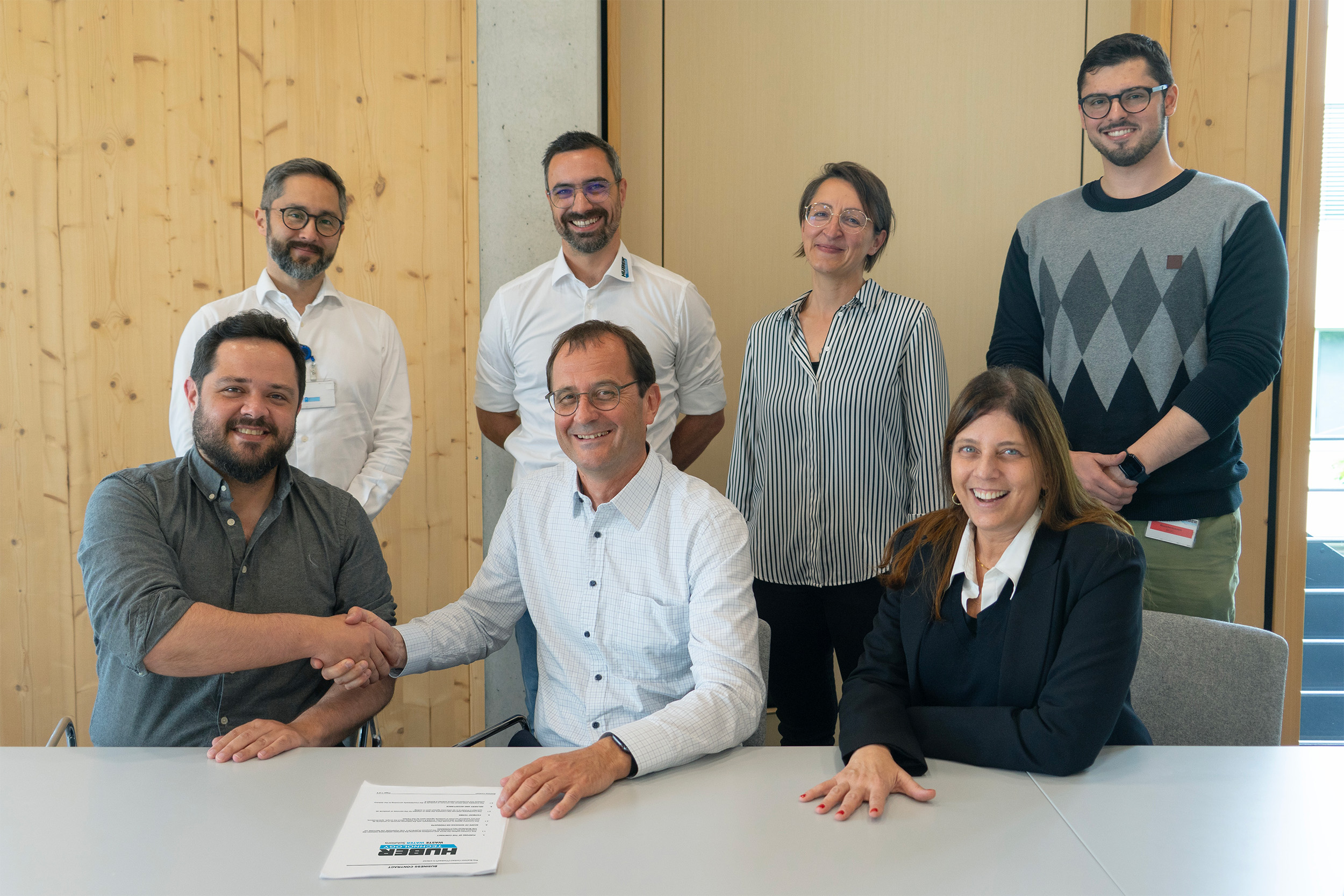 The project responsibles at the contract signing in the HUBER Forum: Tales Teixeira (front left, Supply Manager, Andrade Gutierrez S.A.), Eiki Higaki (back left, Director of Engineering, Construtora Elevação) and Nícolas Vannucchi (back right, São Paulo Commercial Manager, Andrade Gutierrez Construções e Serviços), with Rainer Köhler (front center, Chief Technology Officer, HUBER SE), Elaine Conchon (front right, Managing Director, HUBER do Brasil), Maximilian Agly (2nd from left, back, Regional Sales Director South America, HUBER SE), Cathrin Gleissl (2nd from right, back, Designer Technical Operations, HUBER SE).