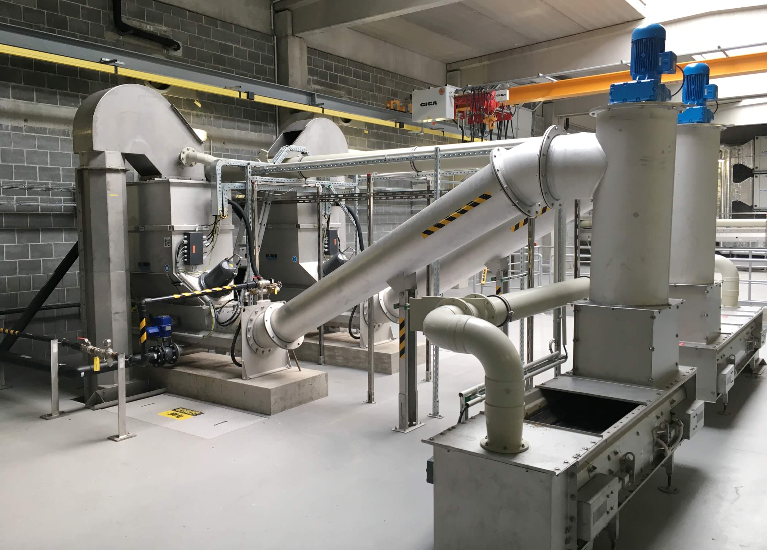 HUBER Screenings Wash Press WAP® SL after a vertical conveyor. The pressed screenings are passed over a grinder and transported to container loading. HUBER Screenings Wash Press WAP® SL after a vertical conveyor. The pressed screenings are passed over a grinder and transported to container loading.