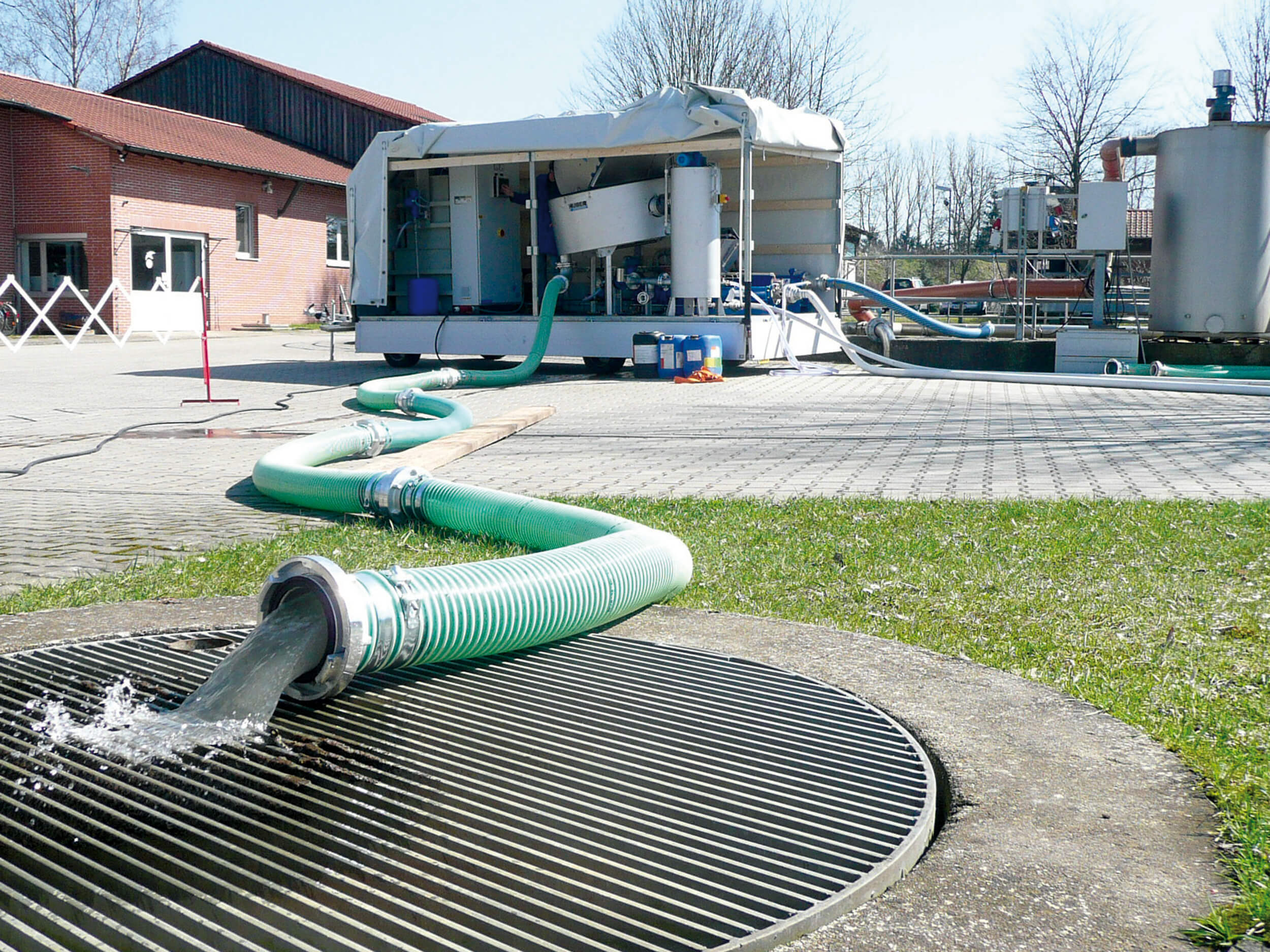 Mobile HUBER Disc Thickener S-DISC mounted on a car trailer, clear filtrate water runs off in the foreground Mobile HUBER Disc Thickener S-DISC mounted on a car trailer, clear filtrate water runs off in the foreground